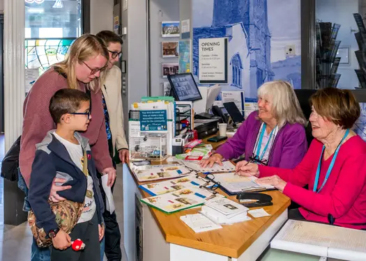 Family visiting museum and speaking to museum reception